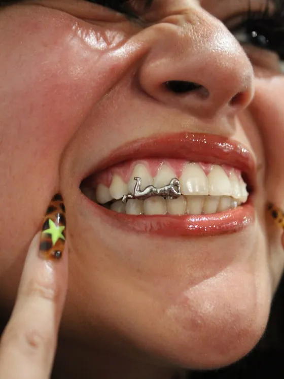 Clienta sonriendo con sus grillz puestos